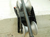 A 90 degree cable guide roller with a robust metal frame and heavy-duty aluminium rollers designed to pull cables gently around corners. Example photo showing roller attached to the corner of a concrete block.