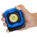 Blue and Black NightSearcher Micro 1100 - 1100 Lumens - Rechargeable Work Light - in person's hand